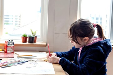 Child drawing by window light © Rawpixel.com