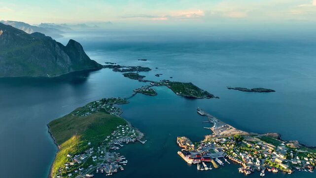 Aerial shot of the ocean meeting the mountains along the beautiful coast of Northern Norway near the town of Reine