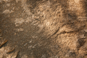 Naklejka premium Rock surface with texture showing natural patterns and colors under sunlight in an outdoor setting