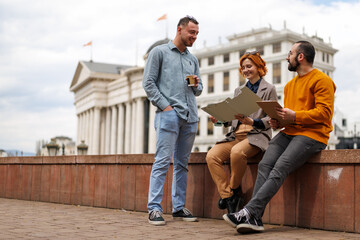 Friends meet in city square to discuss plans while enjoying coffee in a lively urban setting during the afternoon hours on a cloudy day © Nikola Spasenoski