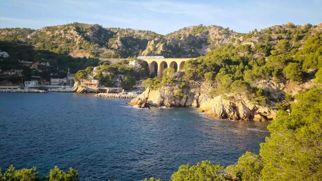 The Grand Mejean port and a railway bridge in the Cote Bleue by the Estaque mountain range and the Mediterranean Sea, South of France