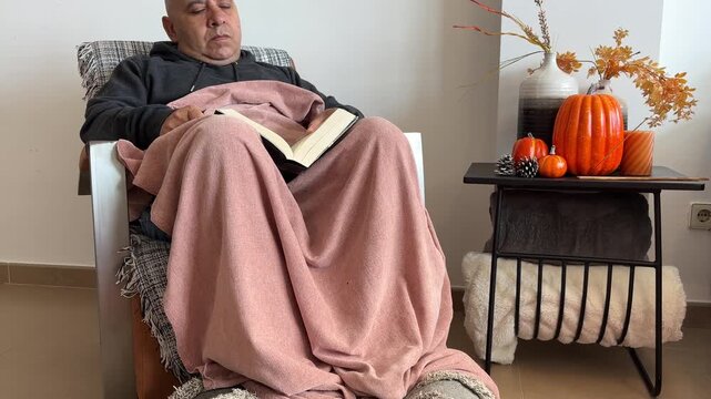 Tilt up de hombre leyendo en sill&oacute;n oto&ntilde;al