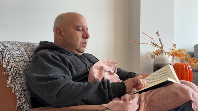 &Oacute;rbita de hombre leyendo libro en sal&oacute;n oto&ntilde;al