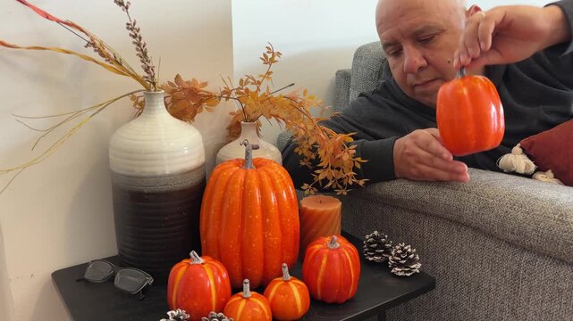 Dolly in de hombre colocando calabazas decorativas