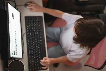 Fototapeta premium Child uses computer at home for study or play