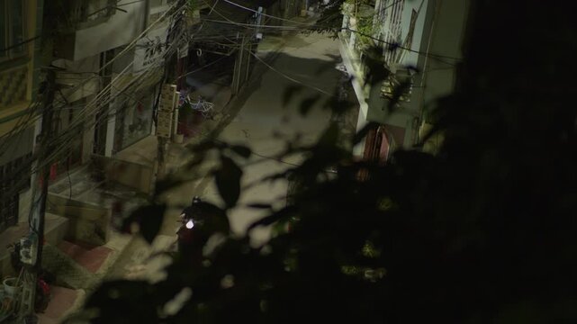 Cao Bang, Vietnam - 3rd November 2025 : Motorbike traveling through a narrow residential street at night in Cao Bang