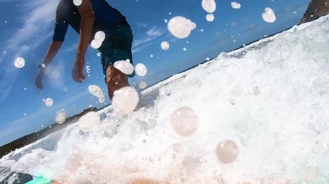 Slow motion POV of a surfer riding a wave and falling off the surfboard in the ocean with dynamic water action and cinematic motion.