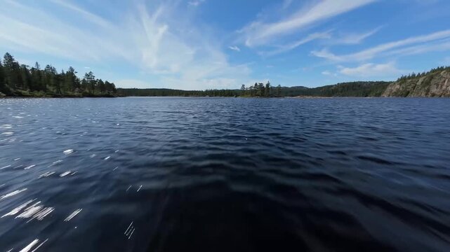 Cinematic Low Aerial View of Calm Fjord Lake under Ble Sky with Clouds