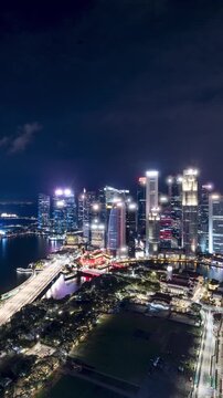 Time lapse of Marina Bay and the Singapore skyline at night. Vertical Video.
