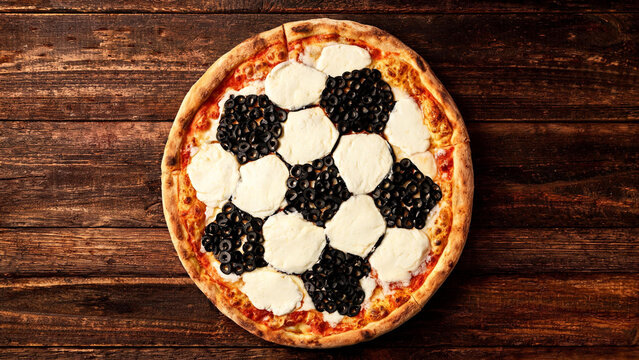 Creative football soccer ball pizza black white pentagon pattern 
mozzarella olives wooden table world cup party food