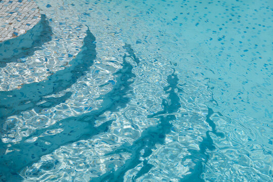 aqua steps and blue water surface of swimming pool with ripples