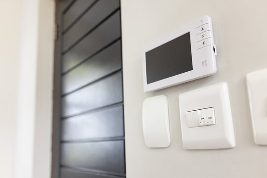 Monitor is showing blank screen while handset and dimmer are resting on wall beside louvered door