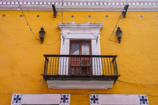 Iconic historic building facades featuring traditional talavera tile patterns and ornate balcony terraces in downtown Puebla, showcasing the rich colonial architectural heritage