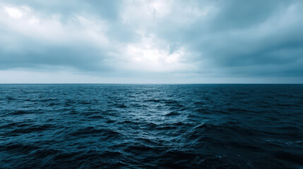 Obraz premium Expansive Ocean Meets Overcast Sky: Moody Seascape with Uniform Waves and Heavy Clouds for Travel or Design