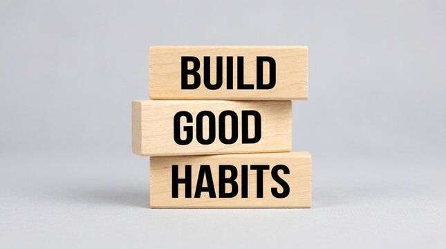 Stacked wooden cubes display the message build good habits in a balanced studio composition.