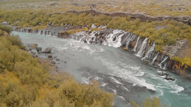 Hraunfossar Waterfalls, Iceland. Aerial view from drone on a summer day. Slow motion