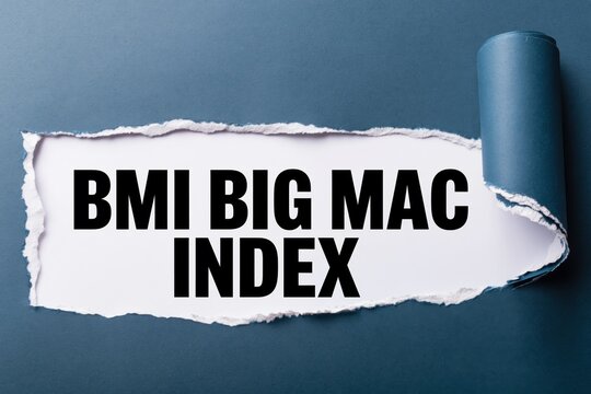 bmi big mac index text revealed under torn dark blue paper