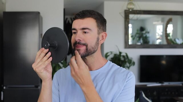 Handsome man looking at the mirror 