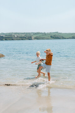 Brother and Sister playing and exploring on a sandy beach during family vacation