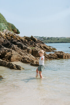 Playful Child Splashing in Waves in Kinsale Beach Ireland