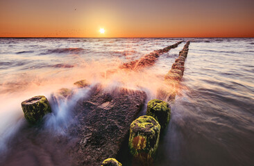 Jarosławiec - plaża - fale rozbijające się o falochron