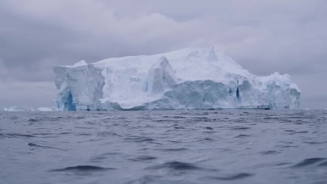 Cinematic Shot of Wild Whale Swimming Near Massive Ble Iceberg