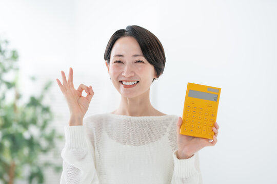 電卓を持つ女性 OK,オーケー,OKサイン,オーケーサイン,丸,了解,簡単,成功,安心,承諾,満足
