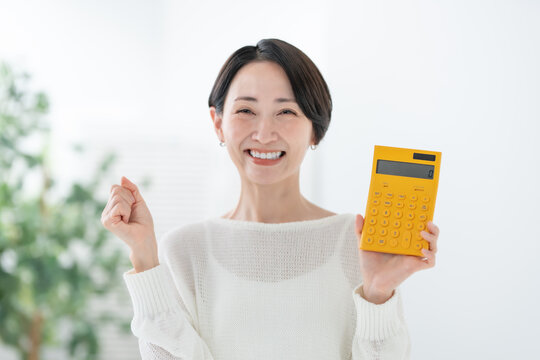 電卓を持つ女性　ガッツポーズ