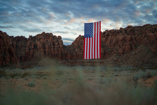 Giant American Flag Hanging Between Red Rock Desert Cliffs at Sunset in Utah to Celebrate the Patriotic America 250 Celebration for 4th of July 06