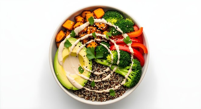 An overhead shot of a colorful Buddha bowl with quinoa, roasted vegetables, avocado, and a tahini drizzle, on a simple white background.