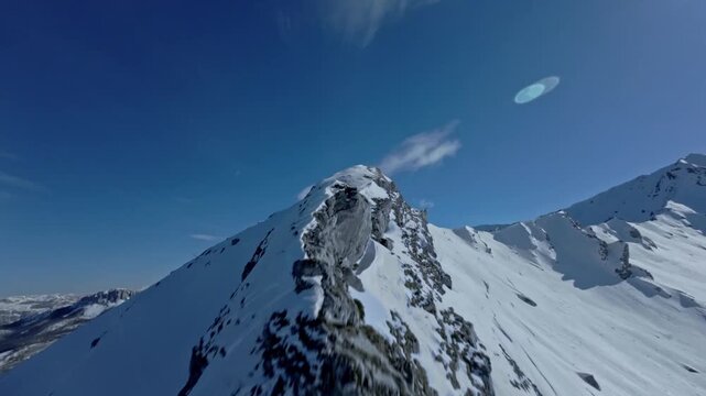 FPV Drone Shot Sweeping Close Over Snowy Mountain Sloe and Peak