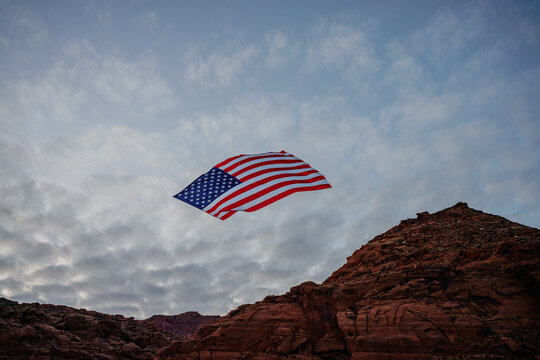 Giant American Flag Hanging Between Red Rock Desert Cliffs at Sunset in Utah to Celebrate the Patriotic America 250 Celebration for 4th of July 05