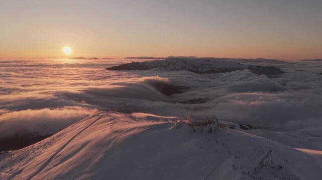 Aerial View of Cloud Waterfall Inversion Over Snowy Muntain Ridge