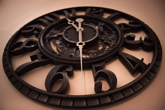 Detail shot of an antique style metal clock face with decorative hands