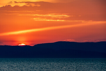 Fototapeta premium Bunter Wolkenhimmel nach Sonnenuntergang am Meer