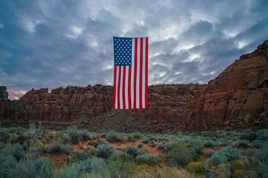 Giant American Flag Hanging Between Red Rock Desert Cliffs at Sunset in Utah to Celebrate the Patriotic America 250 Celebration for 4th of July 03