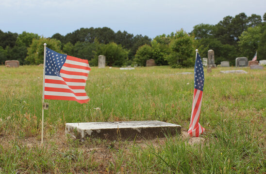 Flags on Grave of Military Veteran at New Hope Cemetery in Bullard TX