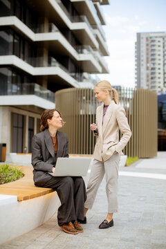 Business meeting between two women outside a modern building during the day