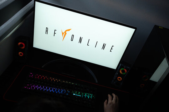 Punta Arenas, Chile &ndash; June 17, 2026: A desktop PC monitor showing the RF Online (Rising Force Online) MMORPG franchise branding on a white background, surrounded by an illuminated gaming keyboard 