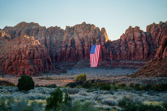 Giant American Flag Hanging Between Red Rock Desert Cliffs at Sunset in Utah to Celebrate the Patriotic America 250 Celebration for 4th of July 02