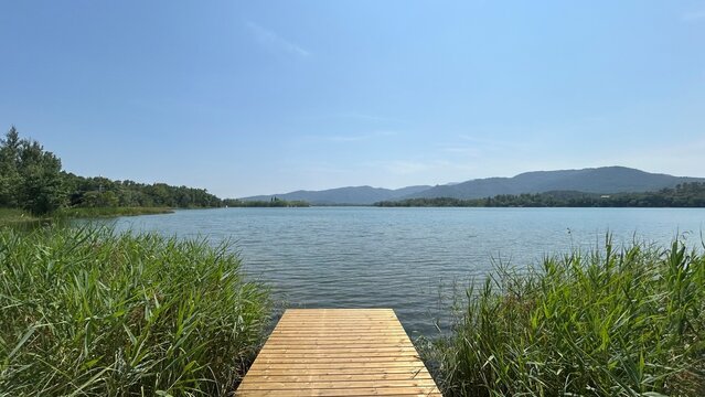 Pasarela de madera en una gran lago rodeado de monta&ntilde;as