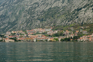 Fototapeta premium Coastal village under rocky mountains in the Bay of Kotor in Kotor Montenegro.