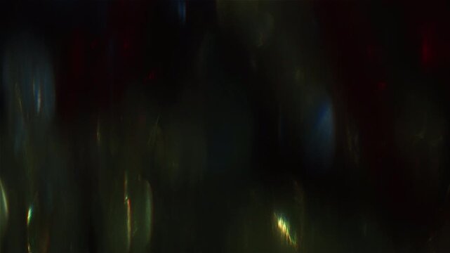 Abstract dark background with shimmering light leaks and lens flares.