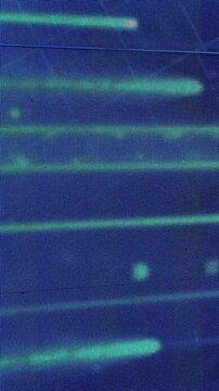Futuristic digital display with glowing vertical streaks of blue and green light, resembling flowing data streams and computer code. 