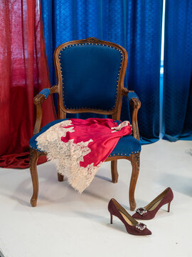 Elegant Red Silk Dress on Vintage Blue Armchair with High Heels