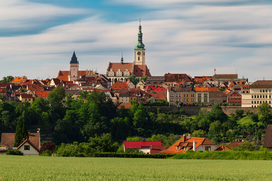 Historic town of Tabor with the Church of the Transfiguration and Kotnov Tower rising above colorful rooftops, green countryside and rolling landscape in South Bohemia, Czech Republic.
