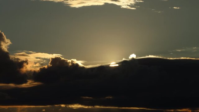 Cinematic time-lapse of a dramatic sunset with dark clouds and a bright silver lining. Golden hour colors and dynamic movement. Perfect for nature and weather concepts.
