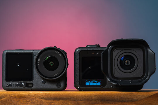 TALLINN, ESTONIA - JUNE 10, 2026: A studio side-by-side comparison shot of the new DJI Osmo Action 6 and GoPro Mission One Pro cameras.