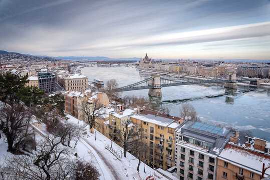 Winter panorama of Budapest with Szechenyi Chain Bridge and Hungarian Parliament over the frozen Danube river, Hungary