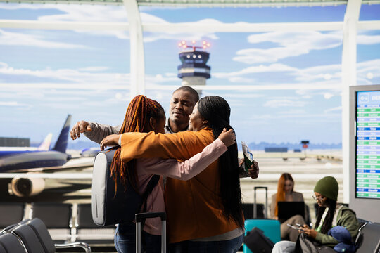 Emotional airport farewell with parents saying goodbye to teen daughter, child leaving to study abroad at university, Young traveler with luggage and passport prepares to airplane alone.
